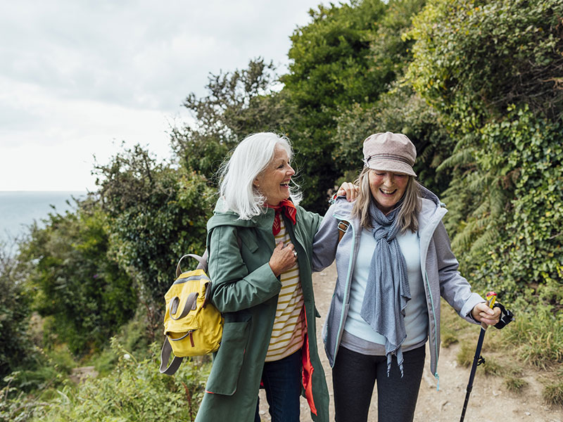 Two elderly women having fun on a hike by the sea. CoQ10 is helping them keep their energy levels up so they can still enjoy life to the fullest.