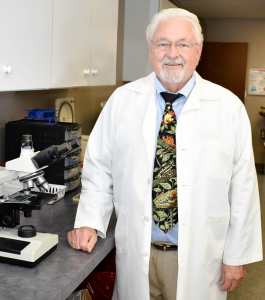 Dr. William V. Judy in a white-coat standing